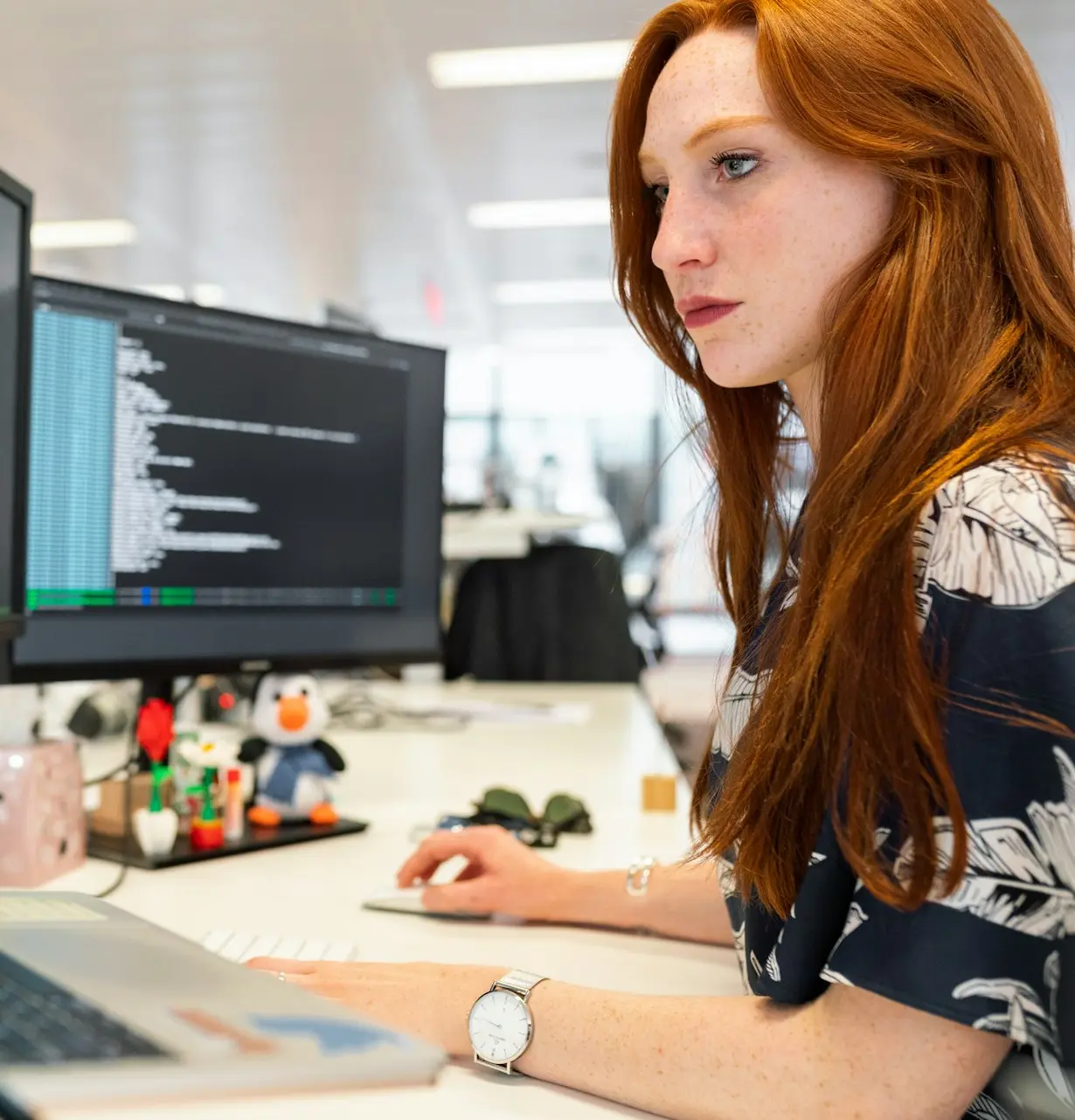 woman in green shirt sitting in front of computer